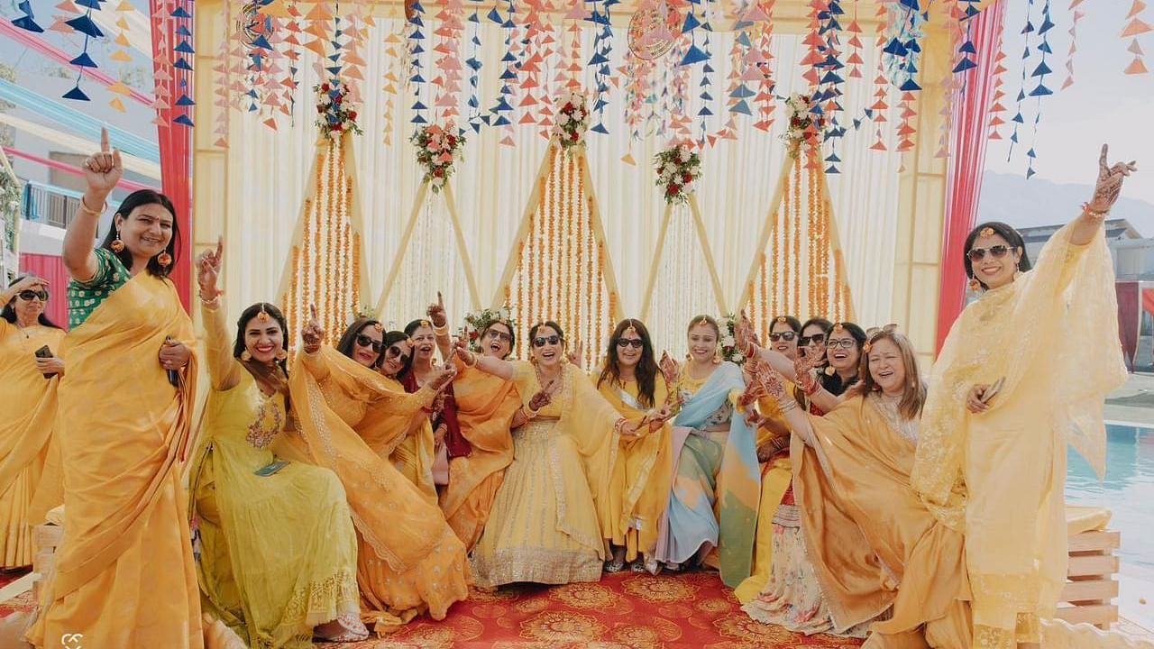 A group of women in colorful dresses posing for a photo at a wedding.