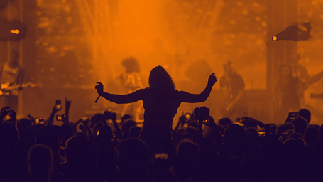 people dancing to a concert with the band playing on the stage