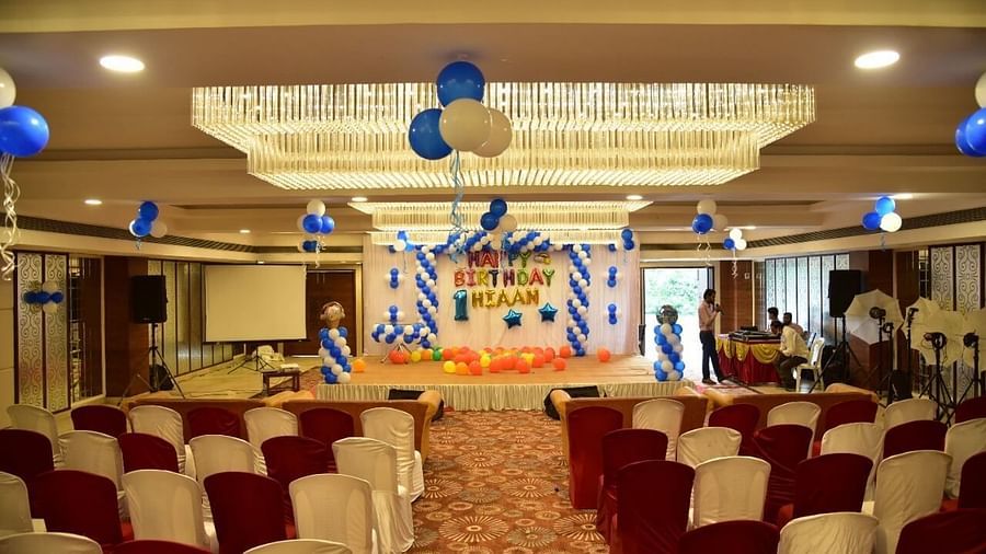 Event hall at Rang Lords Inn with a stage, balloons, and arranged chairs for a gathering