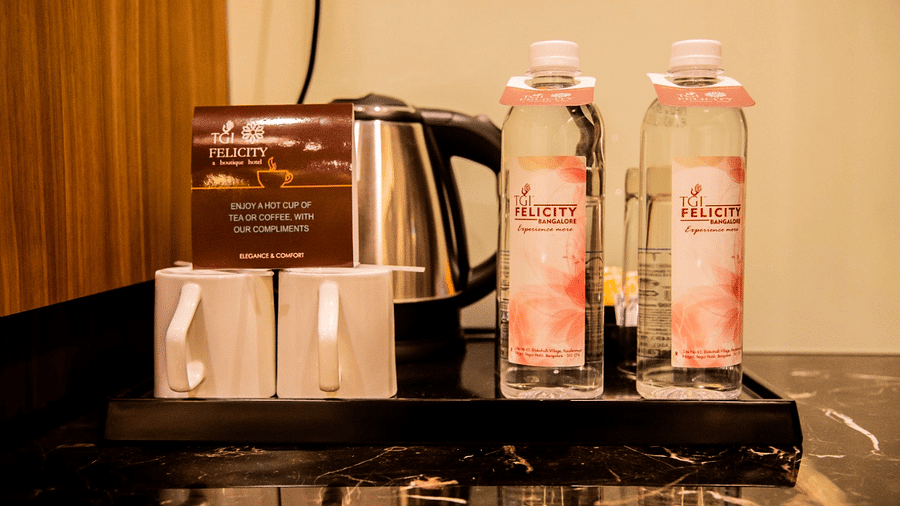 Tray filled with two water bottle, cups and a kettle at TGI Felicity, Bangalore