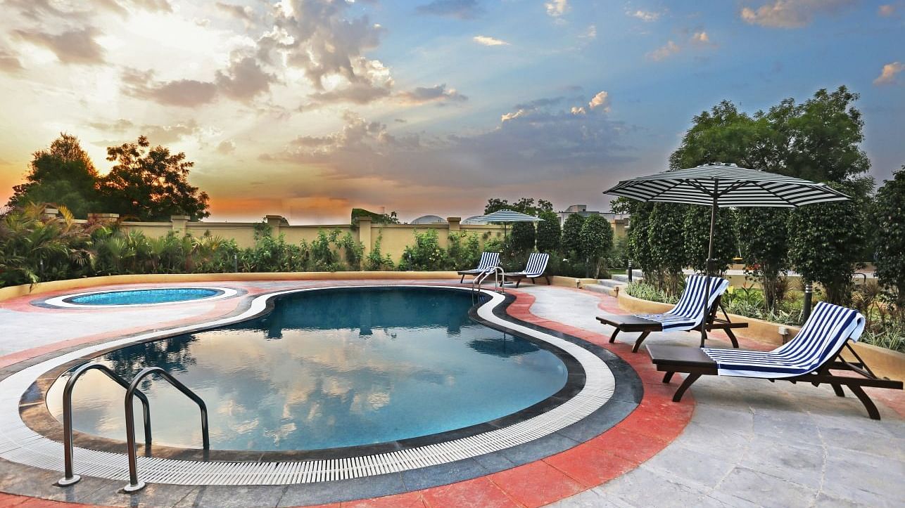 A designer swimming pool with beach beads and an umbrella, during the golden hour