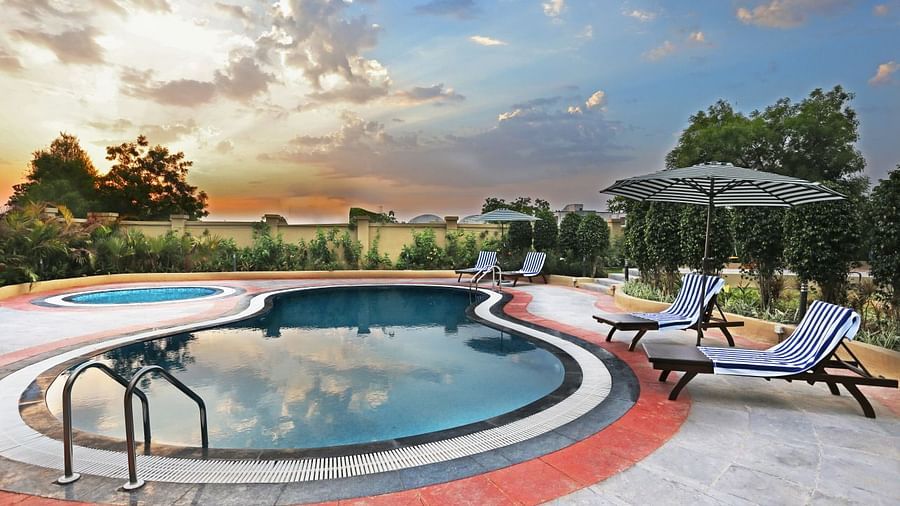 A designer swimming pool with beach beads and an umbrella, during the golden hour