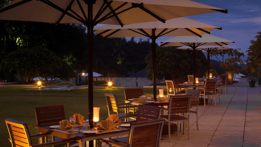 Outdoor seating at Odyssey Restaurant at The Serai Chikmagalur as seen during twilight