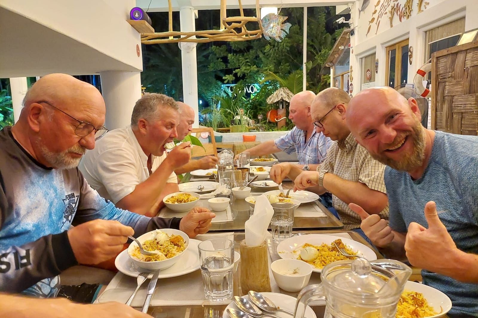 A side shot of multiple people having food at a dining table
