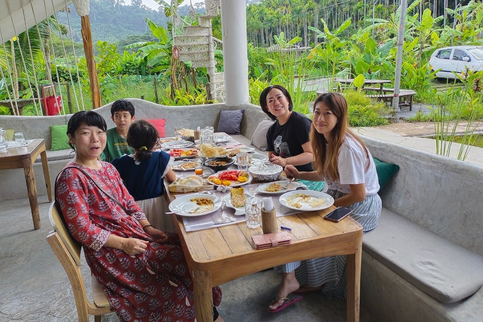 Dining setup outdoor and a group of five people sitting on two adjoining tables can be seen having a good time.