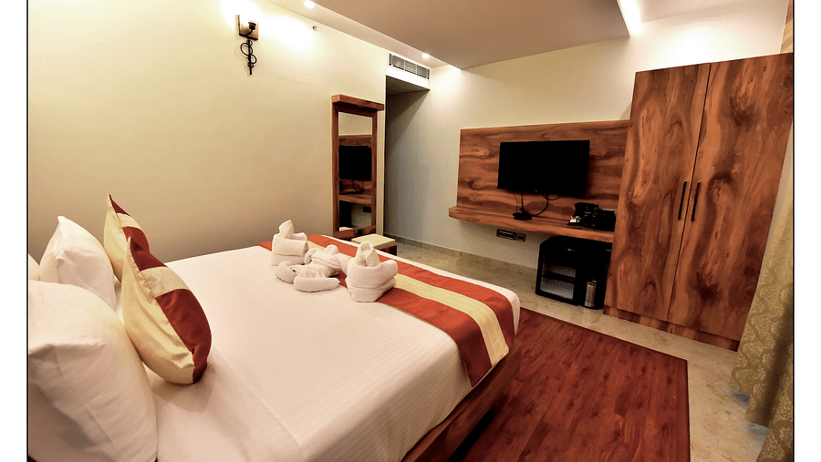 Royal Lotus View Resotel, Bangalore Bengaluru wide angle view of deluxe room with a cosy bed and designed with modern interior 1- Royal Lotus View Resotel