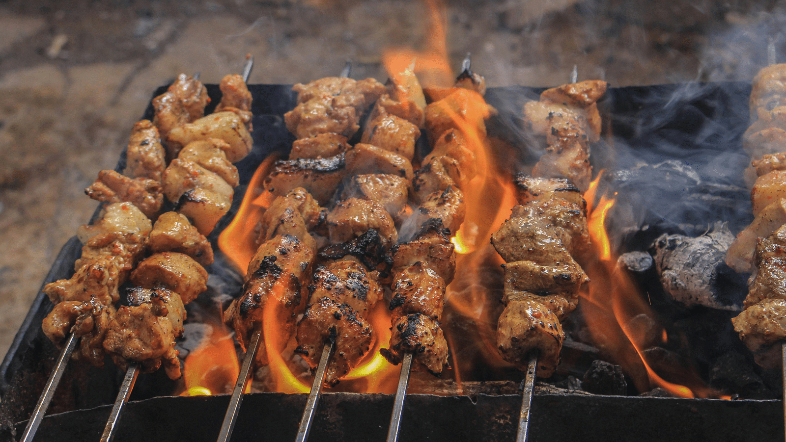 image of several skewers being roasted on fire