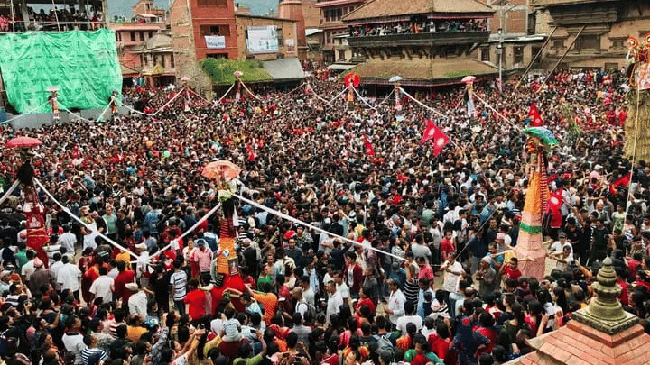 An overhead view of thousands of devotees packed into a heritage square for the annual Ghantakarna festival rituals in Bhaktapur, Nepal.
