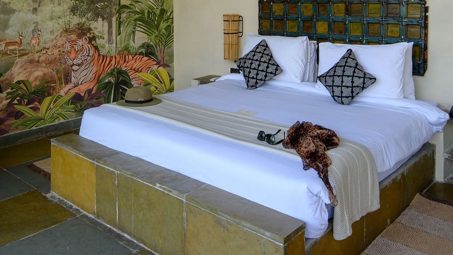 An image of a room with a queen size bed and decorative items - Utsav Camp Sariska