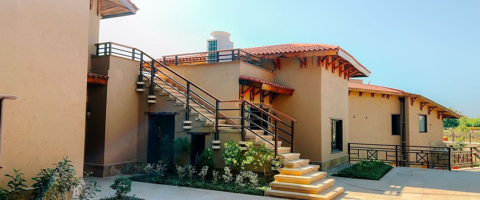 A cluster of beautifully designed resort buildings with outdoor staircases at Aamaghati Wildlife Resort.