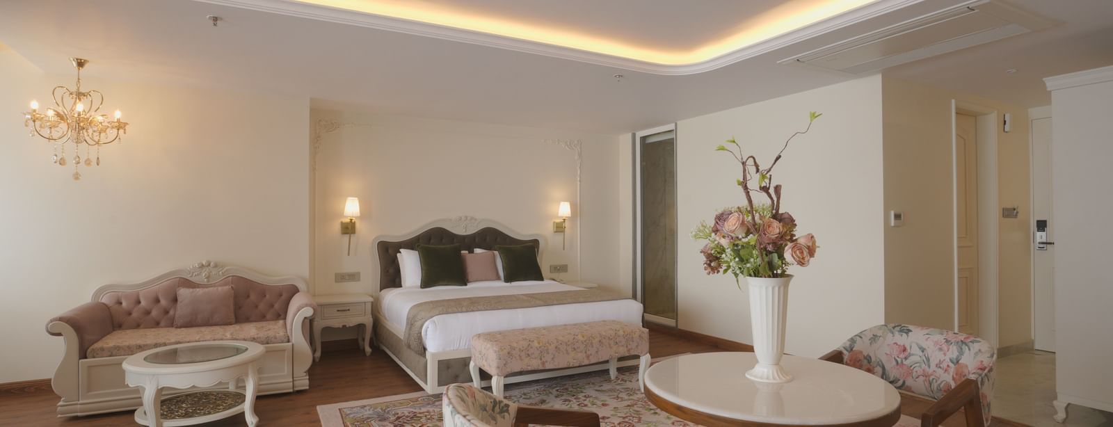 Lounge area with floral chairs, wooden flooring, and warm ceiling lights - Mayfair Cafe & Suites, Dalhousie
