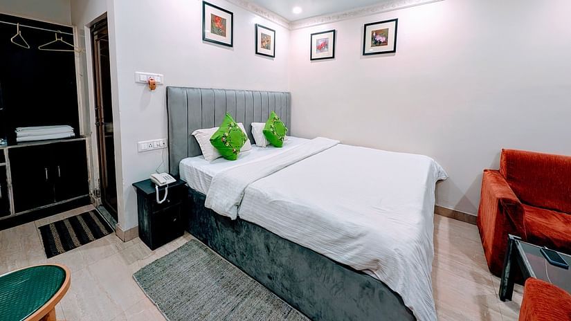 An image of a Cottage Room featuring a double size bed, bedside table, a seating area with sofa and table, and a wardrobe at Rangamati Garden Resort