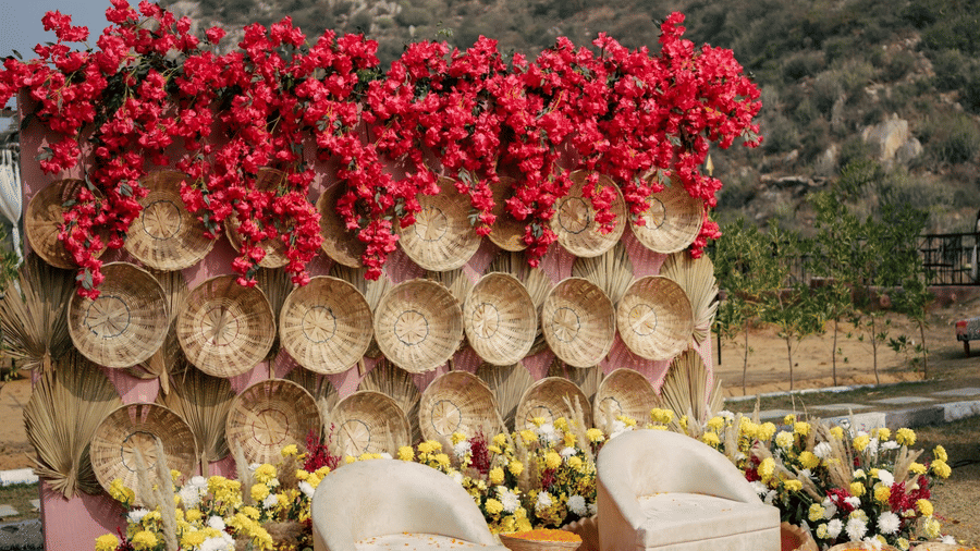 Decorated stage with floral arrangements and patterned-floor seating at Valley by Grassfield, a wedding venue in Jaipur.