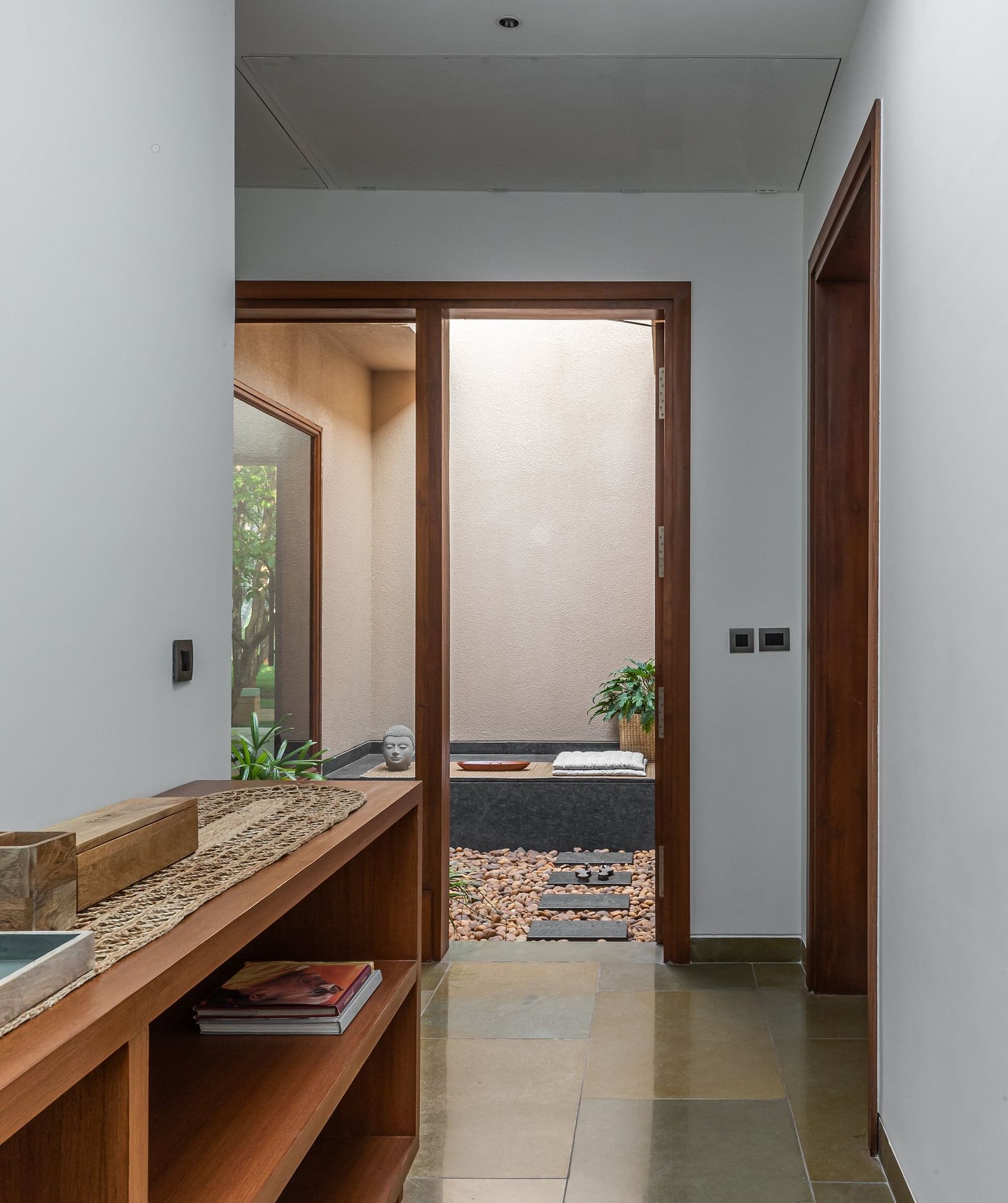 Narrow hallway with wooden shelves, doorway at the end, interior architecture - Shreyas Retreat