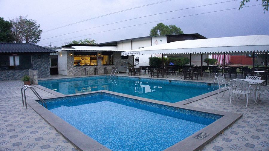 Wide view of pool and bar area during evening. | Vistar Resort, Bengaluru