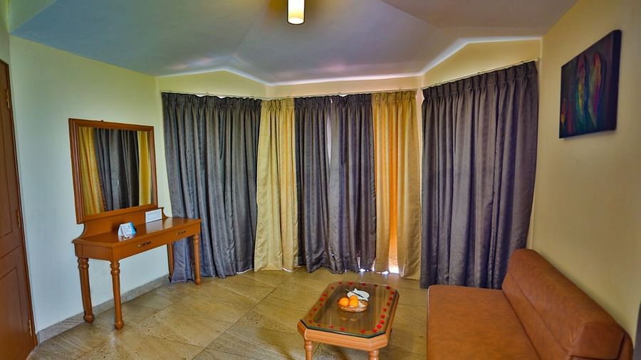 a view of a brown sofa facing a looking glass at La Montana By TGI, Ooty