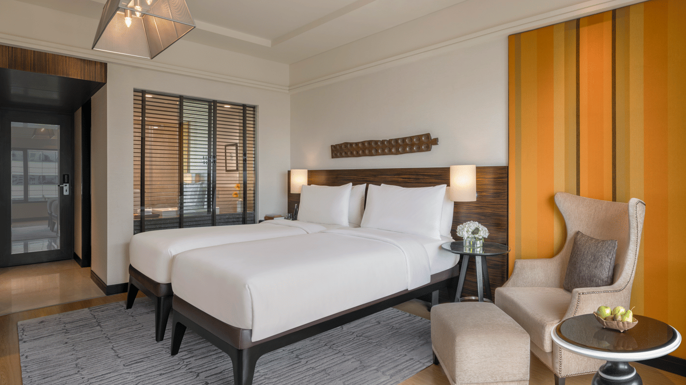 Guest room with double bed, armchair, and bedside lamps at The Raintree, St. Mary’s Road.