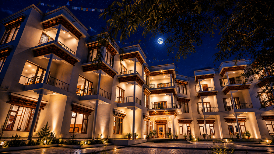 An illuminated multi-storeyed building with sky in the backdrop at night. | Indus Serinity, Leh Ladakh