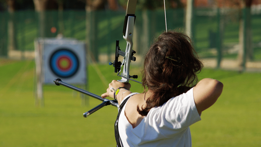 Young person aiming a bow and arrow at an archery target at Nature Trails Durshet.