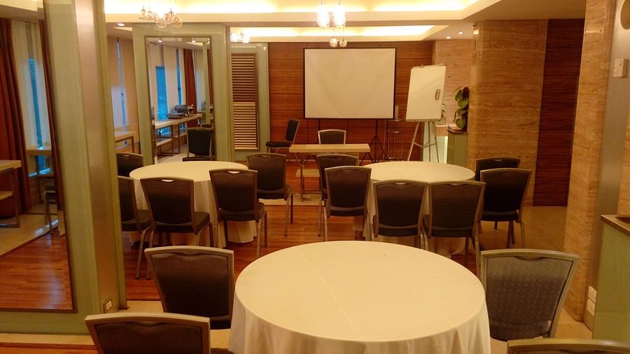 Image of a banquet hall at Mirage Hotel featuring round tables and brown chairs | Mirage Hotel 
