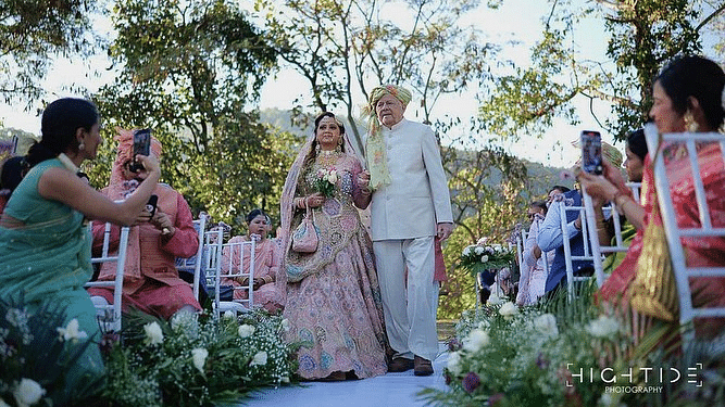 The bride and groom walking on the aisle surrounded by guests at The Sylvan Retreat, Dehradun.