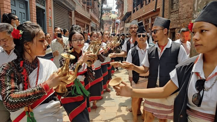 Newar cultural musicians playing traditional brass horns and drums to welcome travelers to a heritage property in Bhaktapur, Nepal.