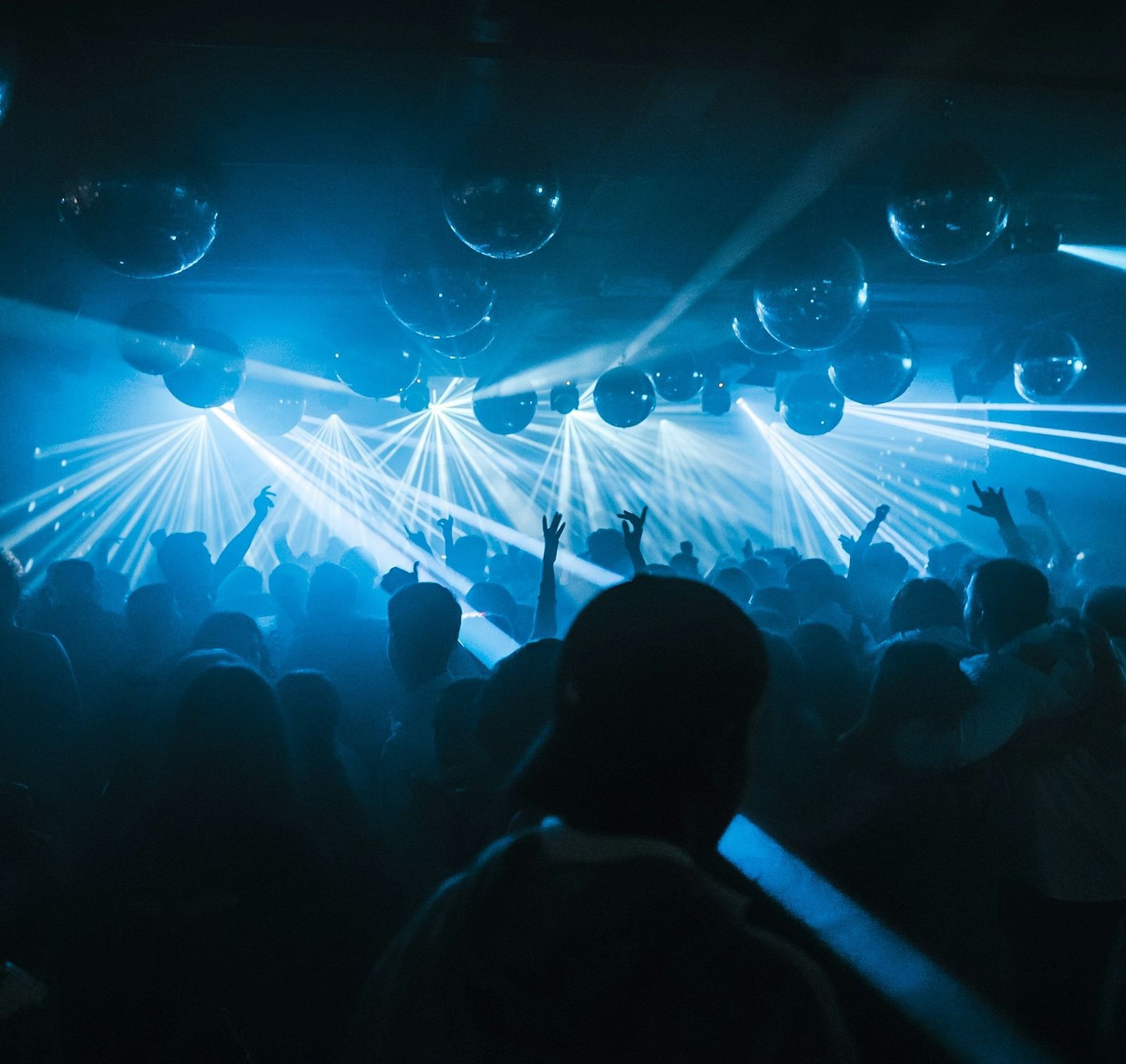 Disco lights flash in vibrant patterns over the dance floor, where people revel in the pulsating beat, their movements lively and carefree
