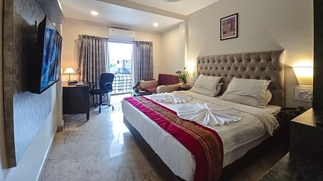 A modern bedroom with a TV, bed, and ambient lighting – The Verda de Miranda Resort.
