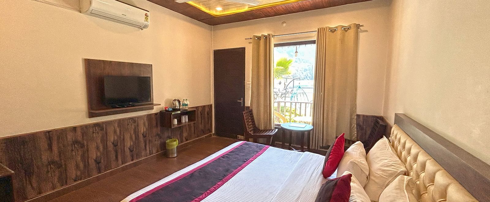 A Luxury Cottage with a large bed in front of the TV at DLS MJ River Resort, Rishikesh.