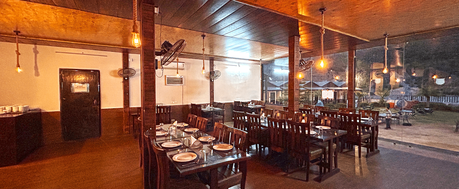 Dining area of the in-house restaurant at DLS MJ River Resort, Rishikesh.