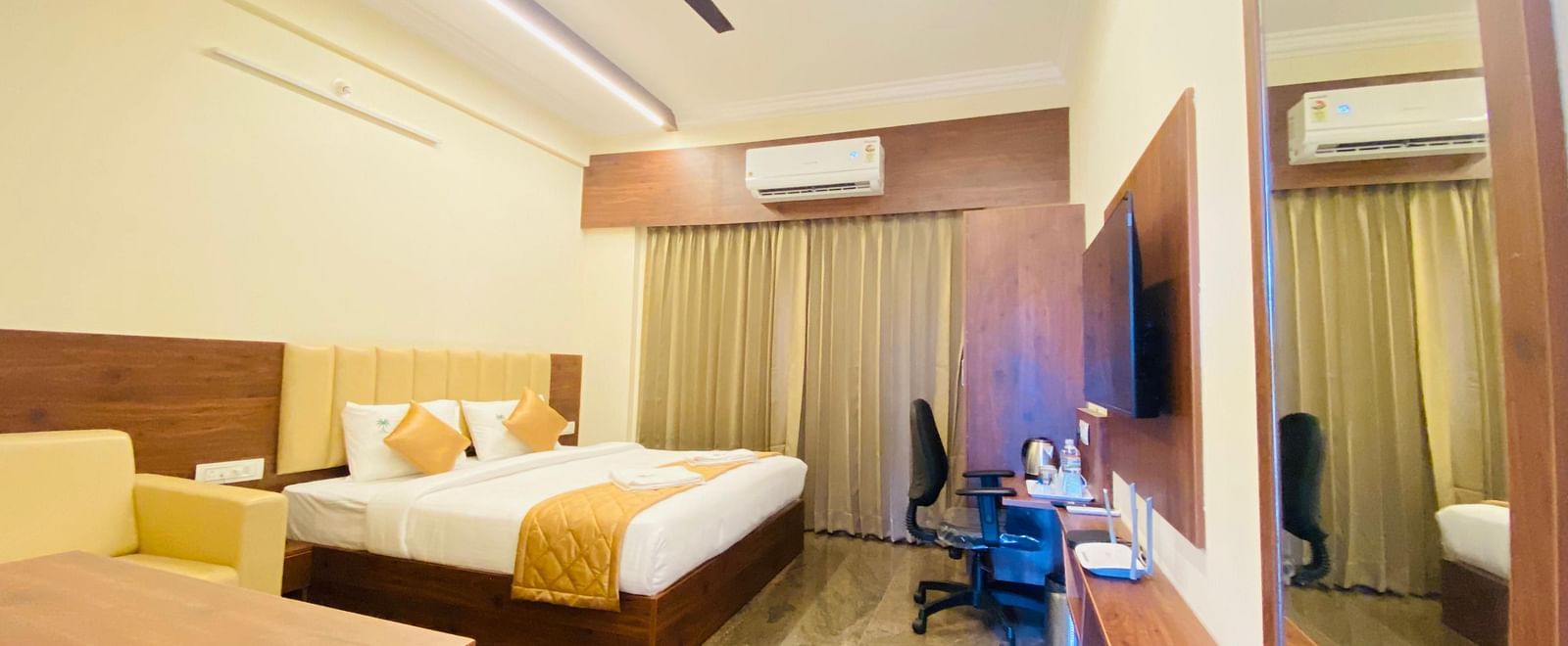 Well-furnished room with queen bed, sofa, and study space for a relaxing stay at Hotel Sahara Tree.
