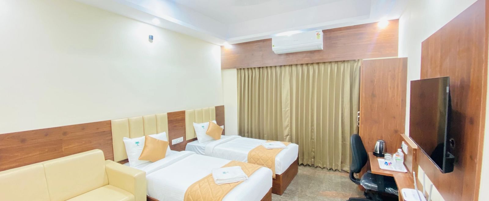 Spacious twin-sharing room with elegant finishes and modern amenities at Hotel Sahara Tree.