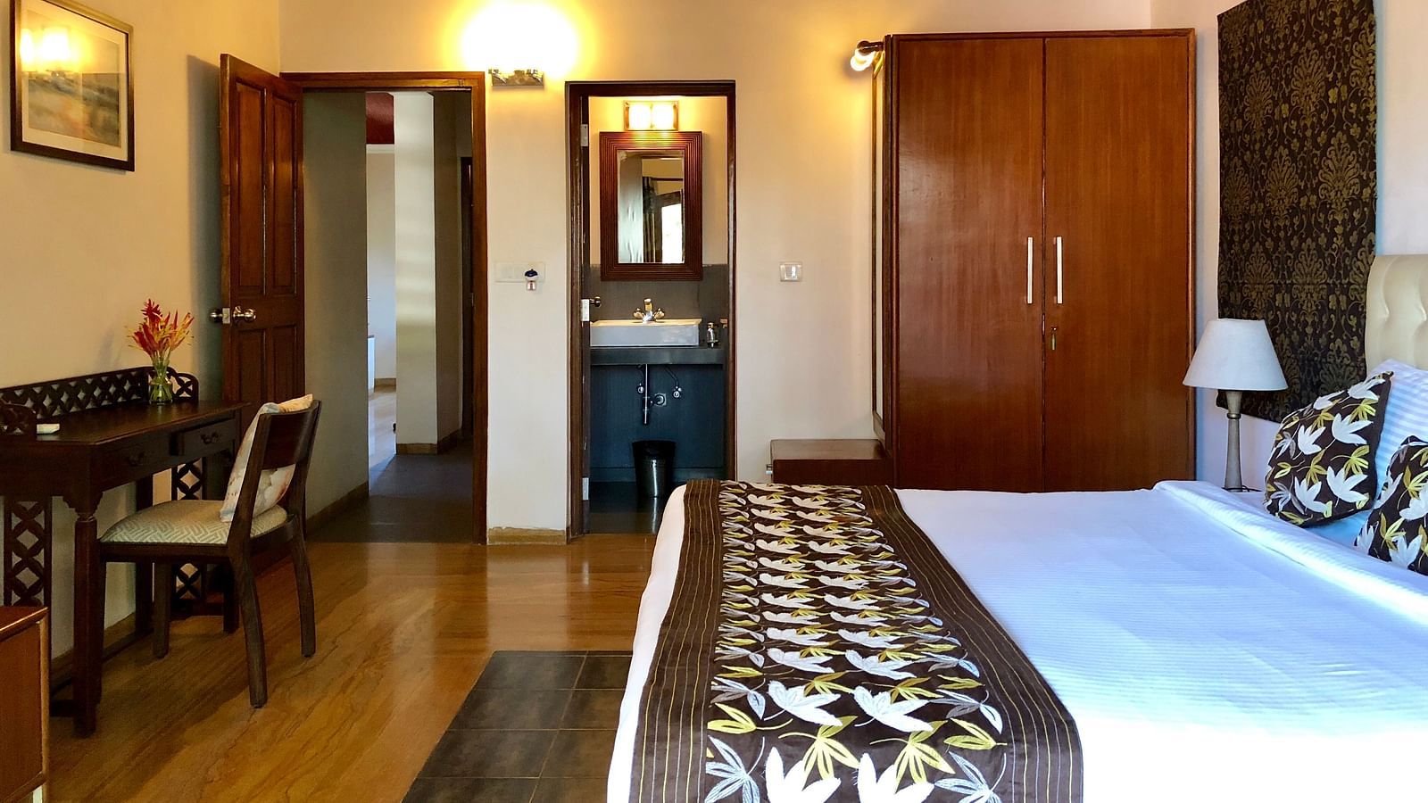 Room featuring a double bed a work desk, a wardrobe and a bathroom