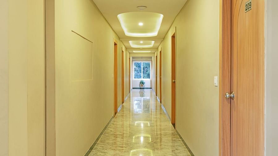Long corridor in a modern building with marble floors and ceiling lights | Mango HIll Central, Ooty