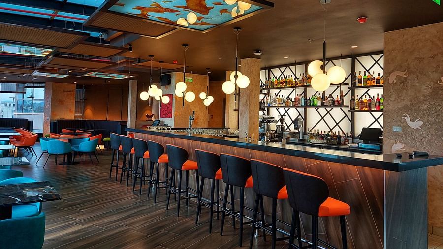 Elegant Asiatic dining area with high-chair seating, stylish ceiling design, and warm lighting