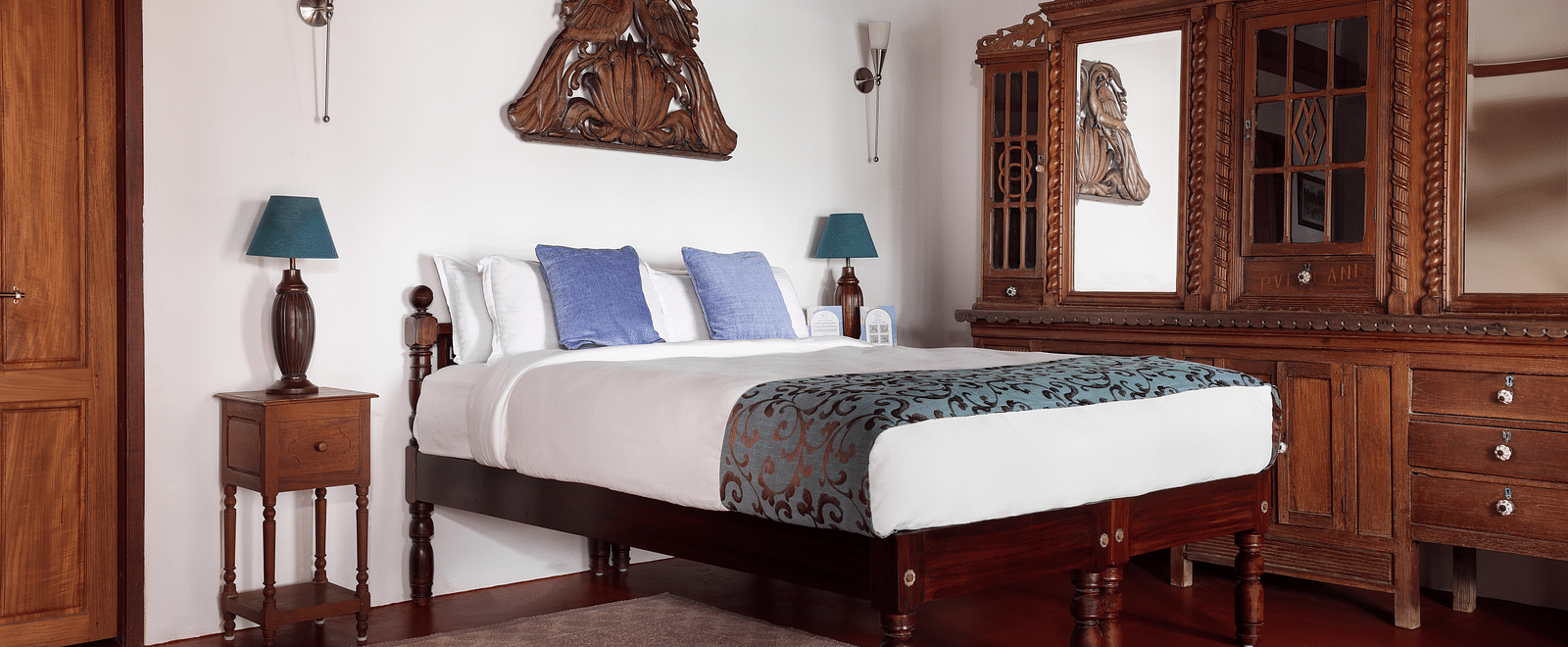 A wood furnished room with a bed, bedside tables, and a dresser - BluSalzz Villas - Muhamma Resort, Alleppey
