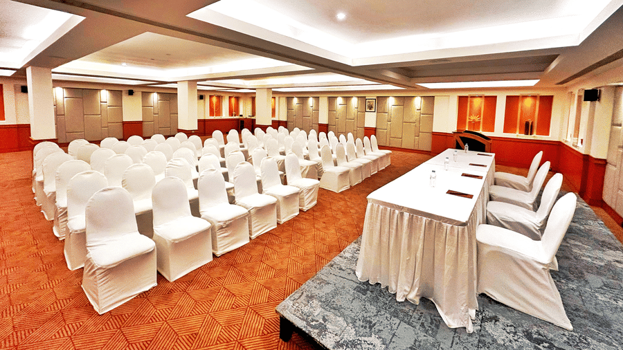 Banquet hall set up in theatre-style seating with white chairs and a head table at The Residency Karur, ideal for conferences and formal gatherings