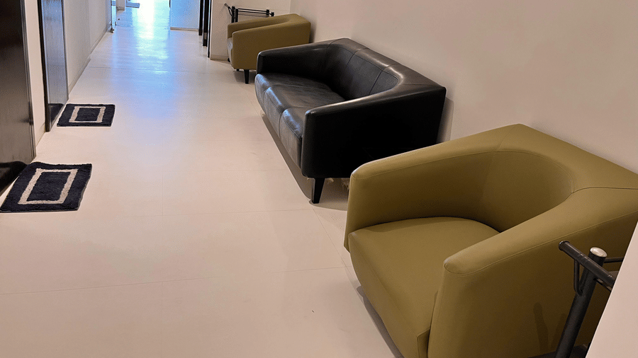 A bright lounge area with comfortable armchairs placed along the wall, offering guests a cosy seating space in a modern setting at Springs Hotel & Spa, Bangalore