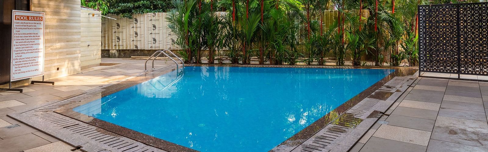 Image of a swimming pool with trees in the background at Calux Grand Inn, Calangute.