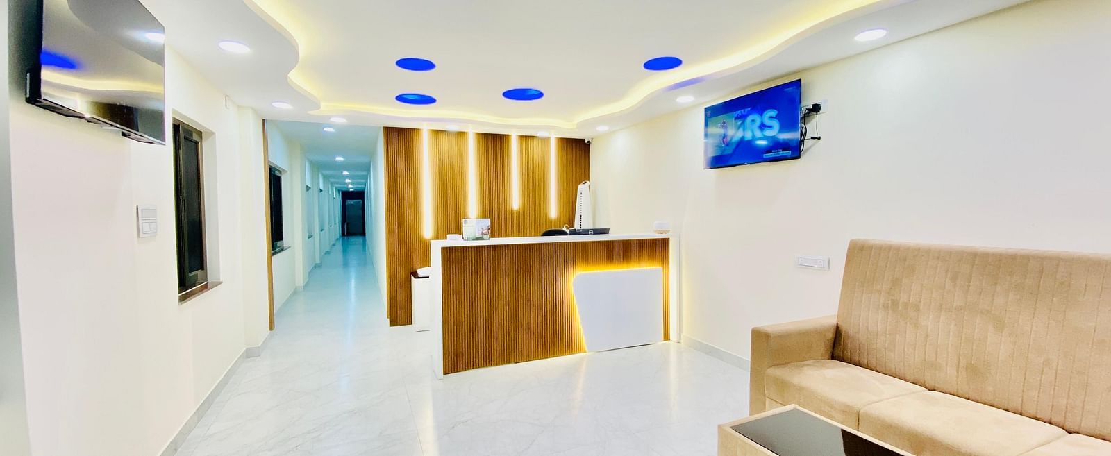 Bright, modern lobby area with white interiors and stylish ceiling lighting at Hotel Sahara Tree.