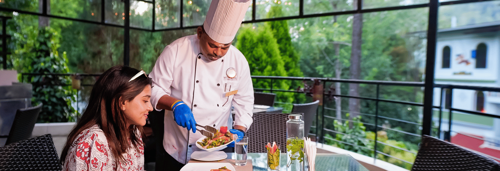 A chef serving food to a lady at WOW Bungalow, Yercaud.
