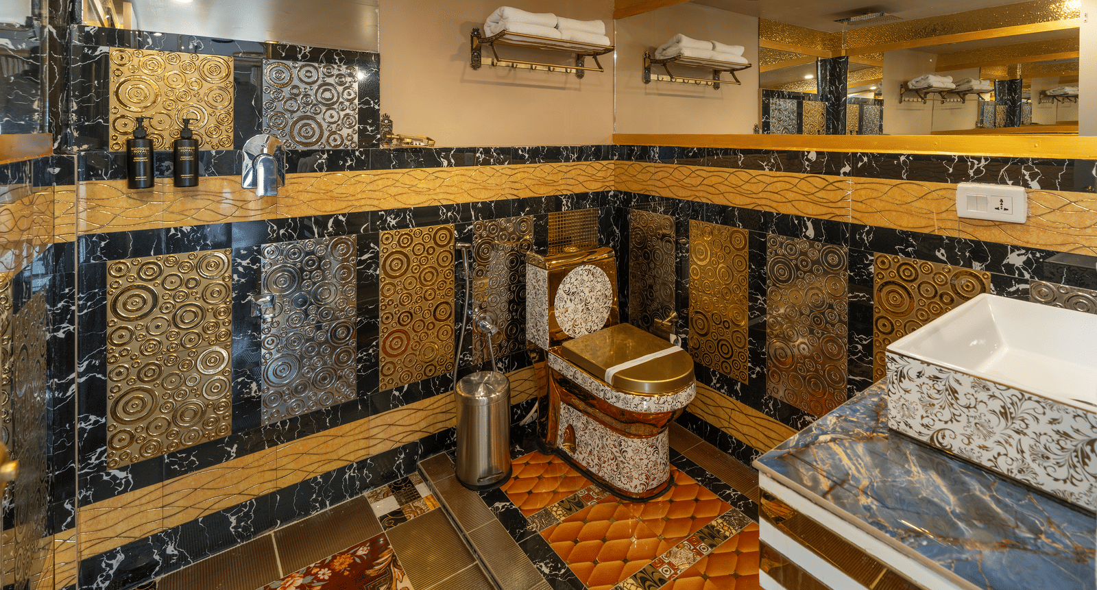 The modern bathroom in the Jacuzzi 180-degree Suite at Parakkat Nature Hotel and Resorts, Munnar, featuring highly textured and patterned wall tiling, mirrored surfaces, and a well-lit vanity area.