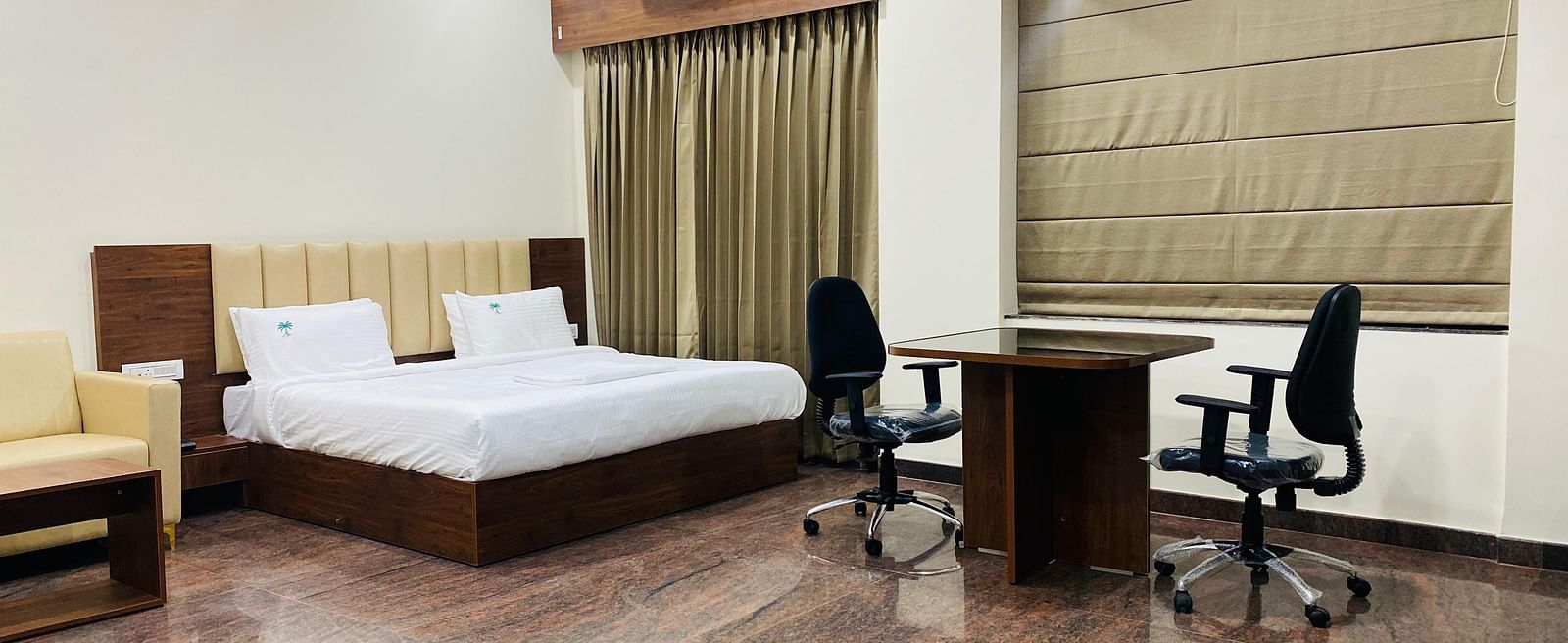 Premium suite with king bed, work desk, and warm tones for business or leisure stays at Hotel Sahara Tree.