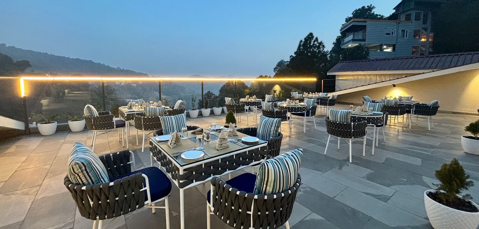 Outdoor dining area at twilight with neatly arranged tables and scenic views – ARNISA Boutique Hotel