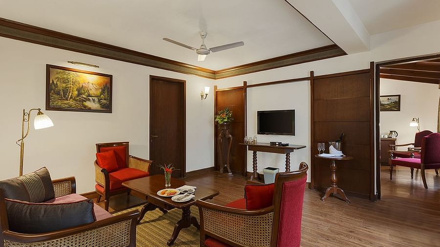 A full view of living room with 3 chairs and a table - the naini retreat, nainital.