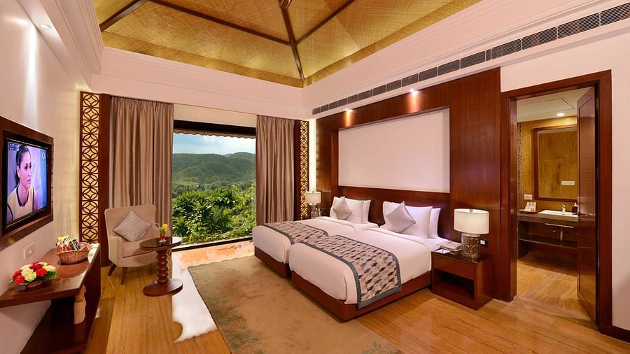 A twin bed with floor to ceiling window inside the grand suite - The Ananta Udaipur