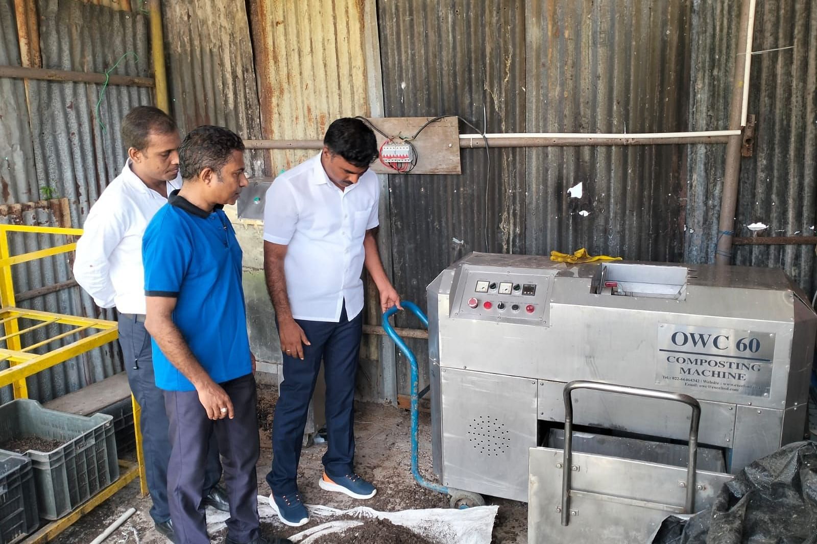 Three man looking at a machine at Coral Reef Hotel & Resort