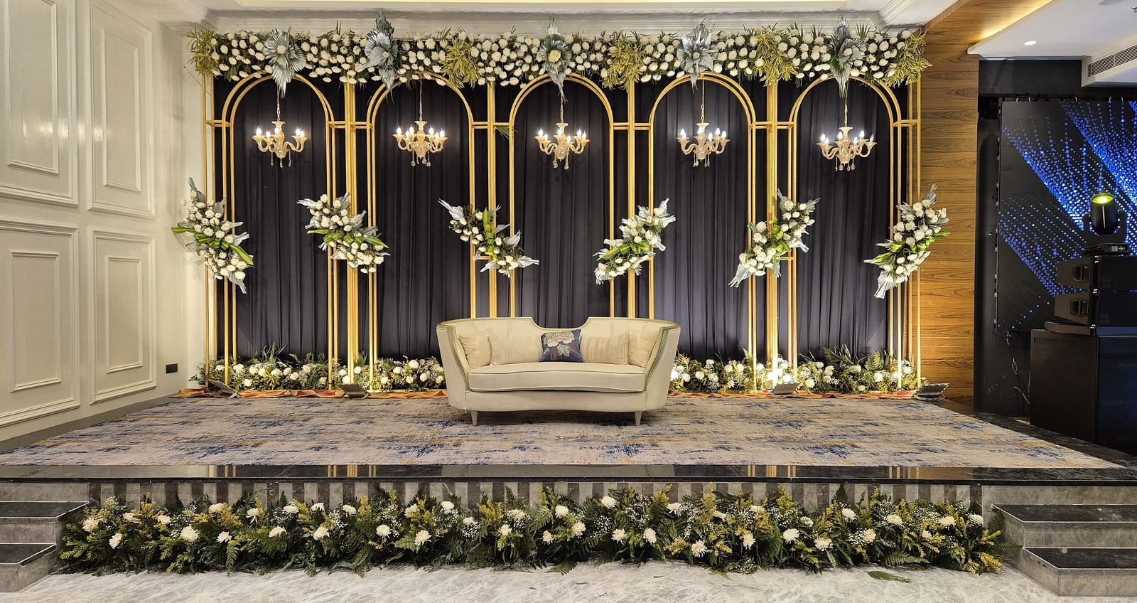 Decorative wedding stage setup with floral arrangements and elegant backdrop at Ramada by Wyndham Sonipat Murthal