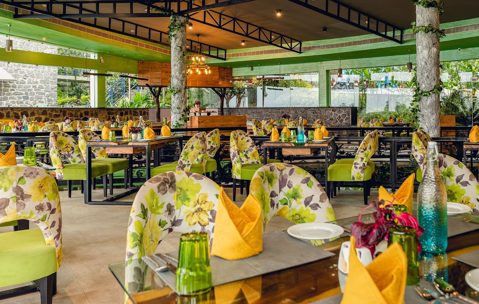 An image of a restaurant with different seating arrangement, bright lighting, and decorative items - Great Trails Yercaud by GRT Hotels