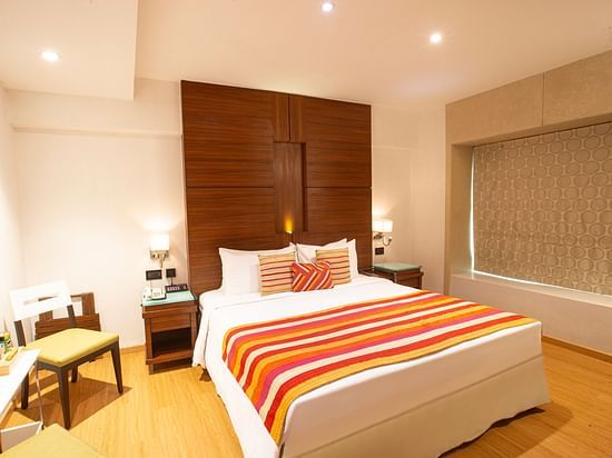A side angle view Executive room with plushy bed.